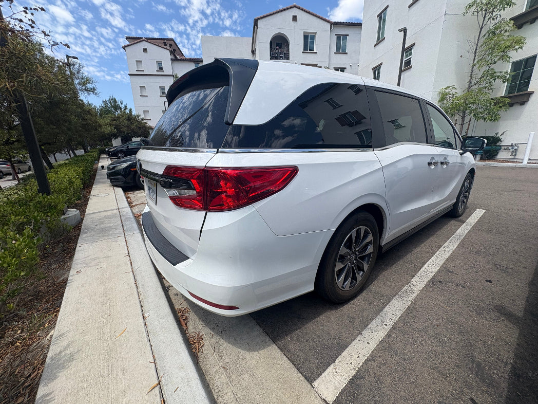 White minivan parked on a street with buildings in the background