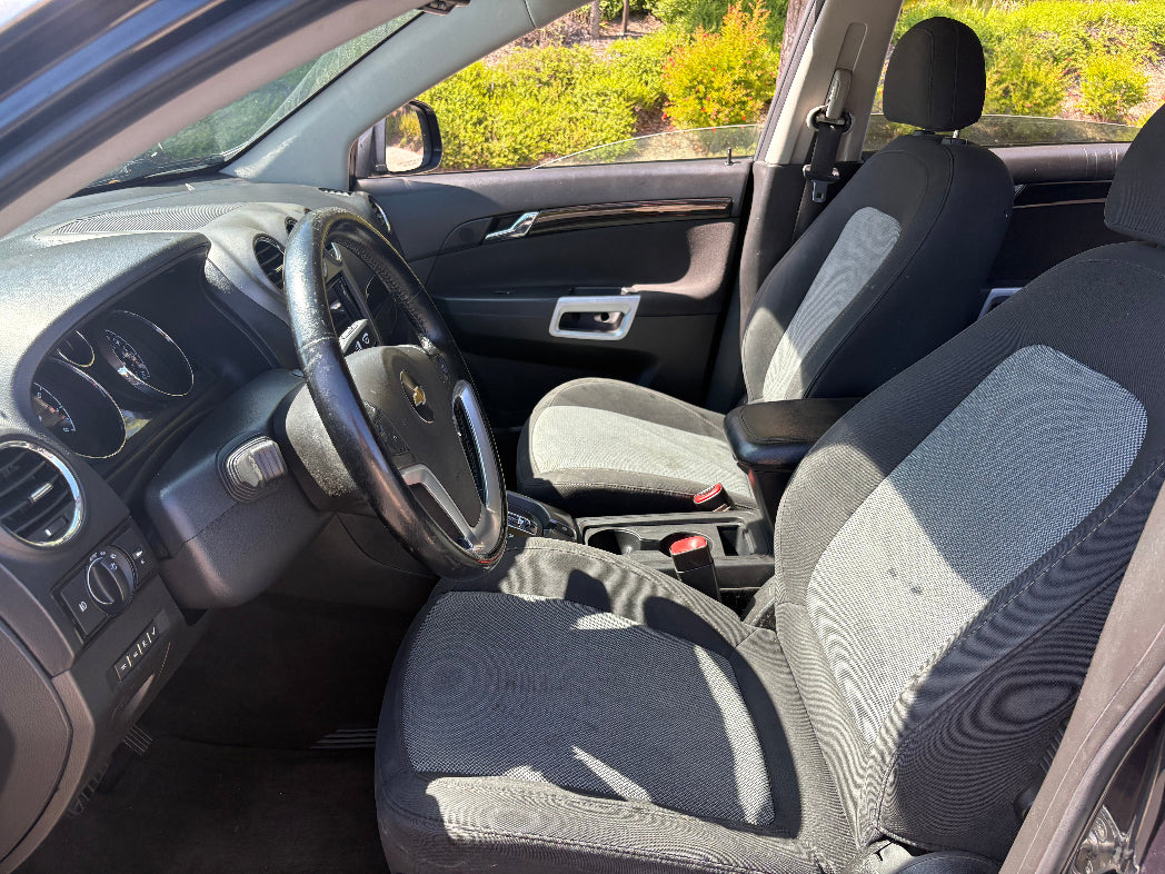 Car interior with gray seats and dashboard, showing signs of wear.