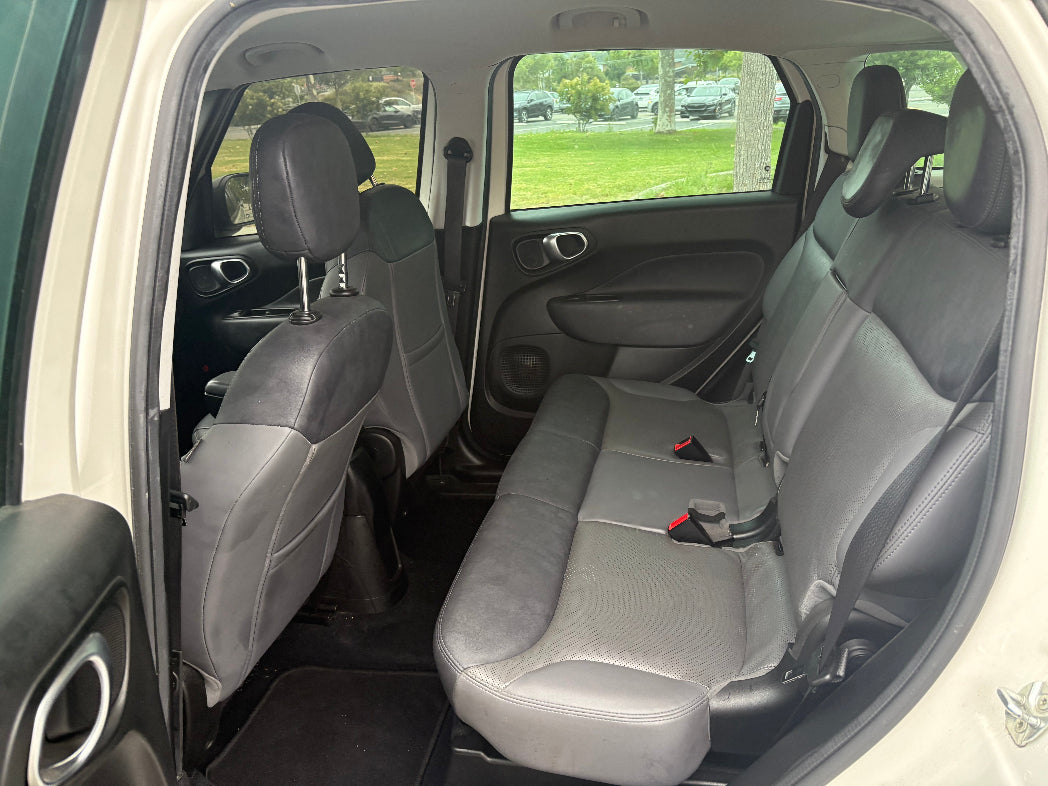 Interior of a car with gray seats and open door showing grass outside