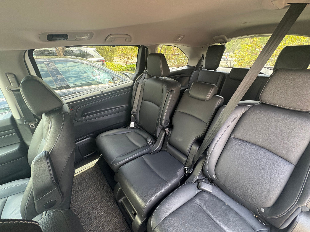 Interior of a car with gray seats and visible windows showing an outdoor setting.