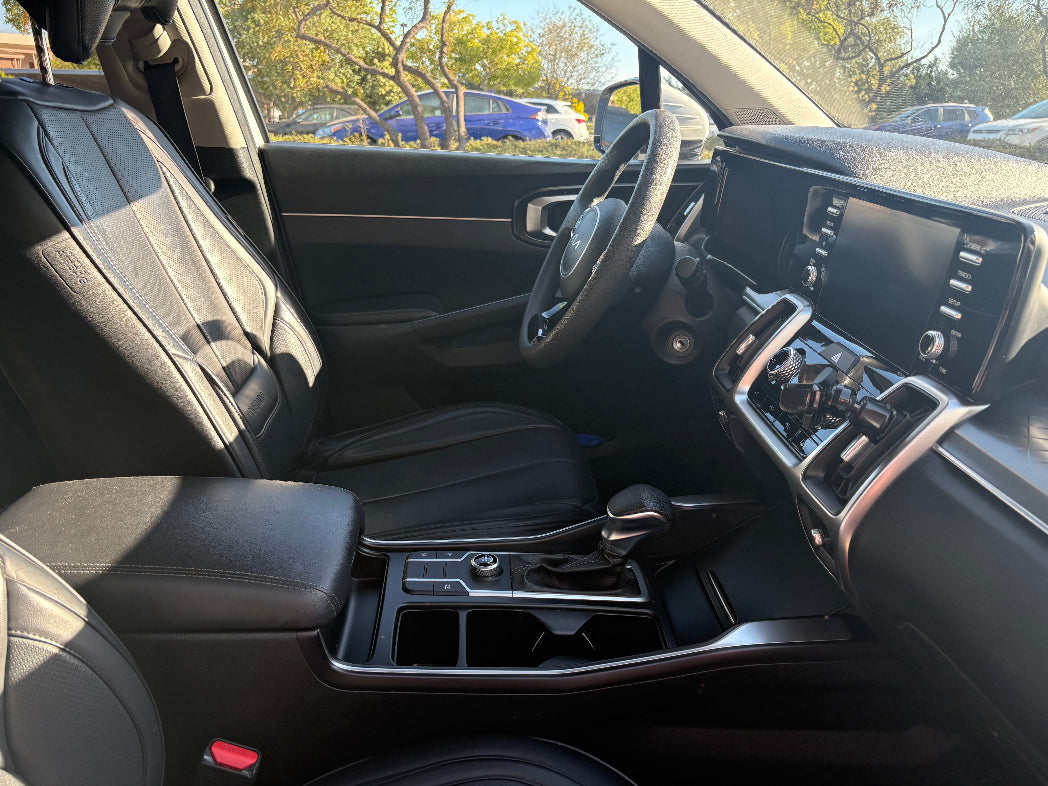Car interior with steering wheel, dashboard, and center console.