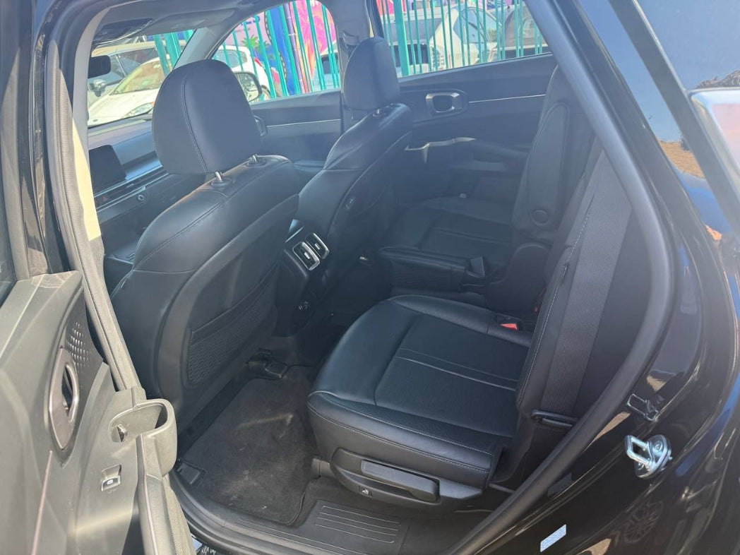 Car interior with open door showing black seats and dashboard.