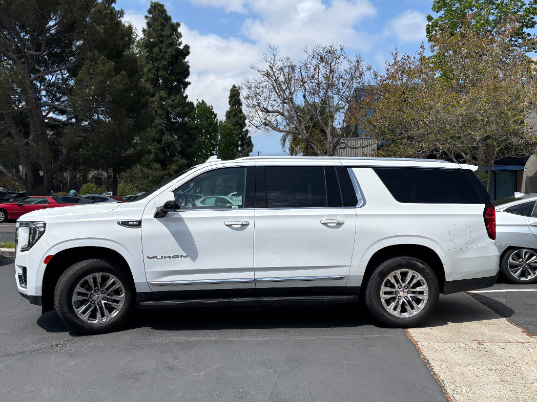 Side profile of full-size white GMC Yukon SUV for rent