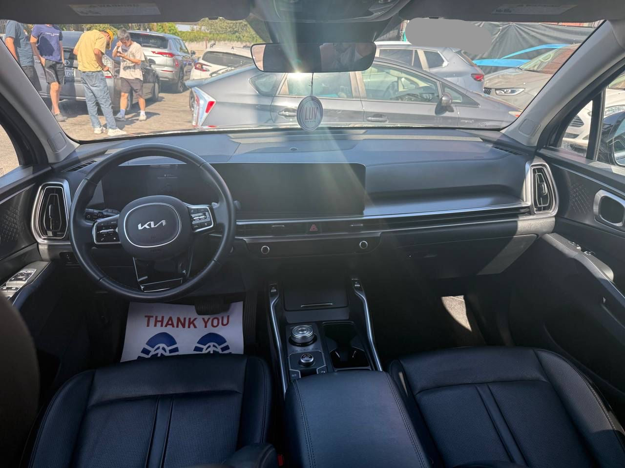 Car rental SUV interior with steering wheel and dashboard, showing a 'Thank You' sign.