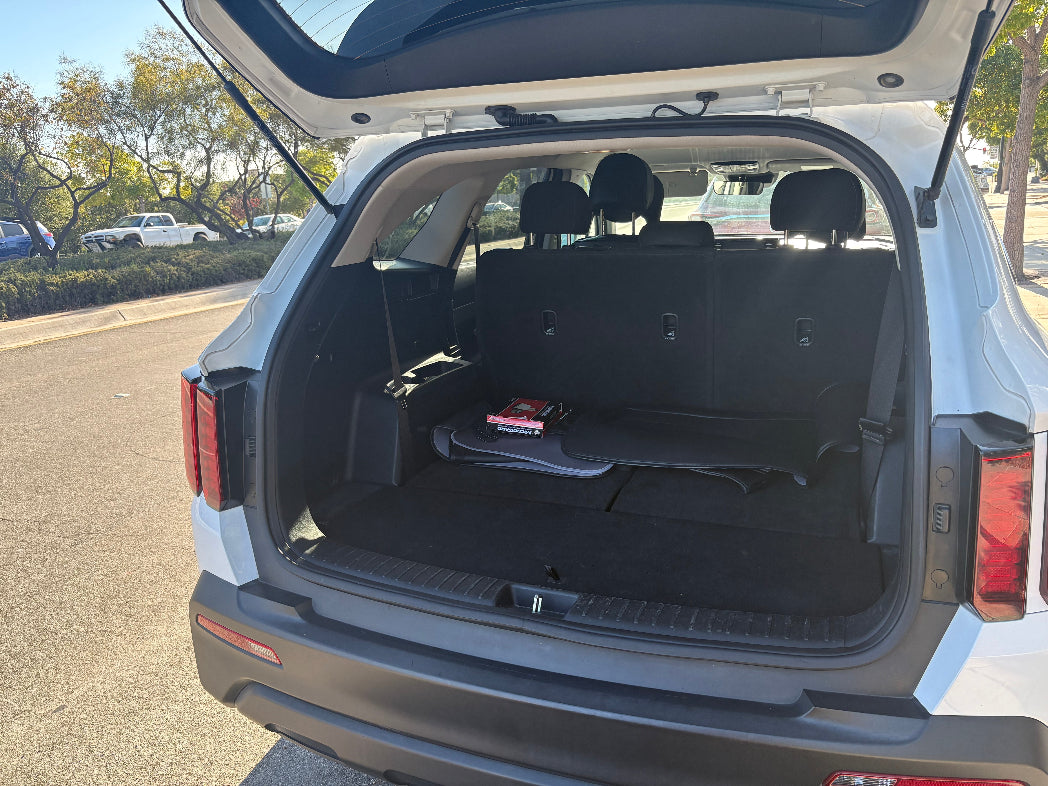 Open trunk of a car with items inside, parked outdoors.