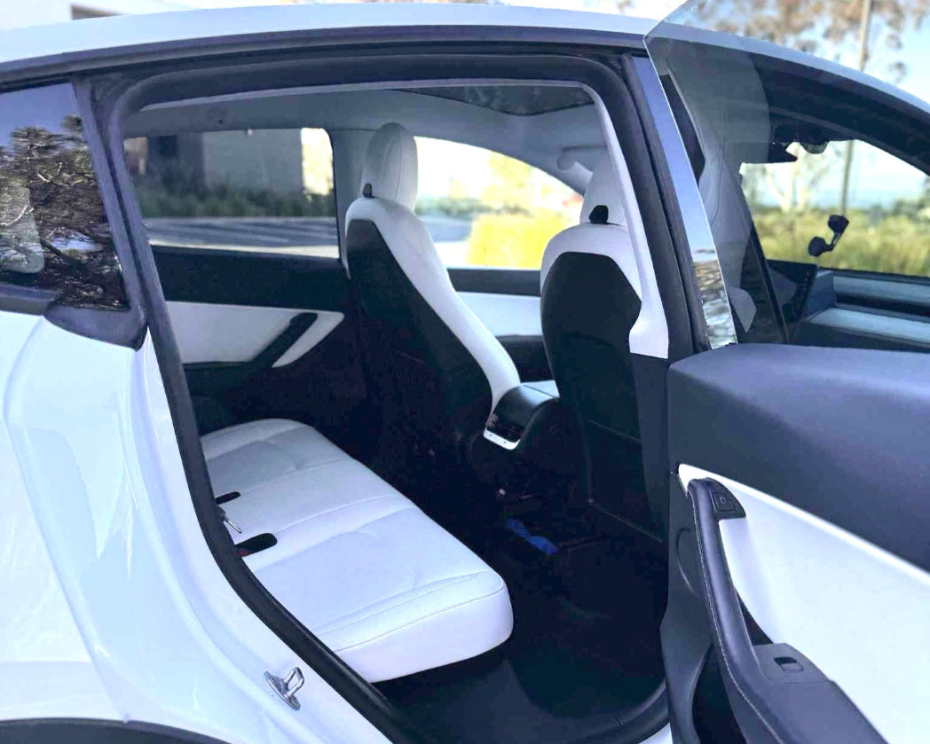 White car interior with open door, showing seats and dashboard.