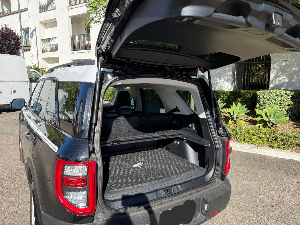 Open trunk of a car with a view of the interior, parked on a street.
