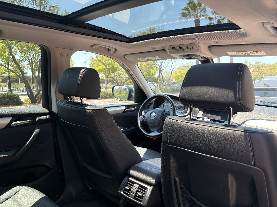 Car interior with sunroof, steering wheel, and dashboard view.