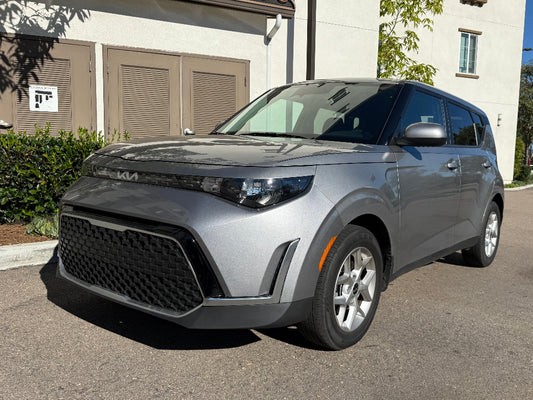 Gray SUV parked on a street with a building in the background