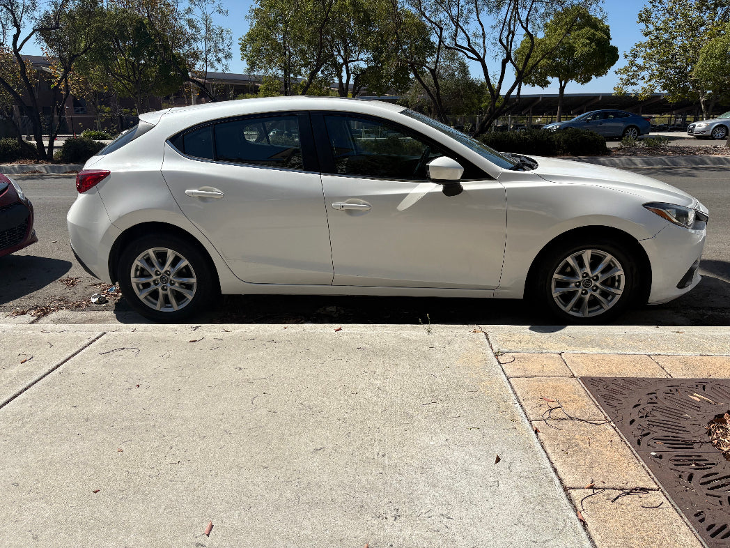 San Diego car rental parked on the side of a street with trees and buildings in the background