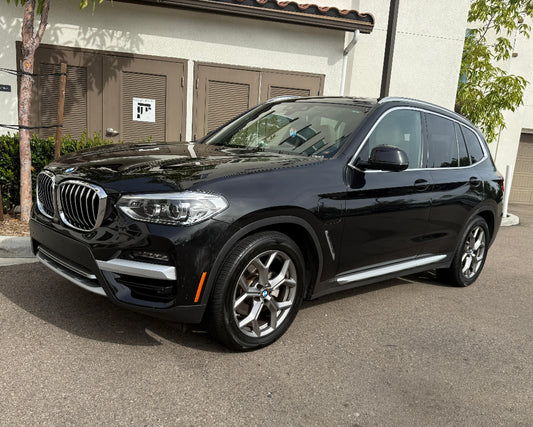 Black BMW SUV parked in front of a building
