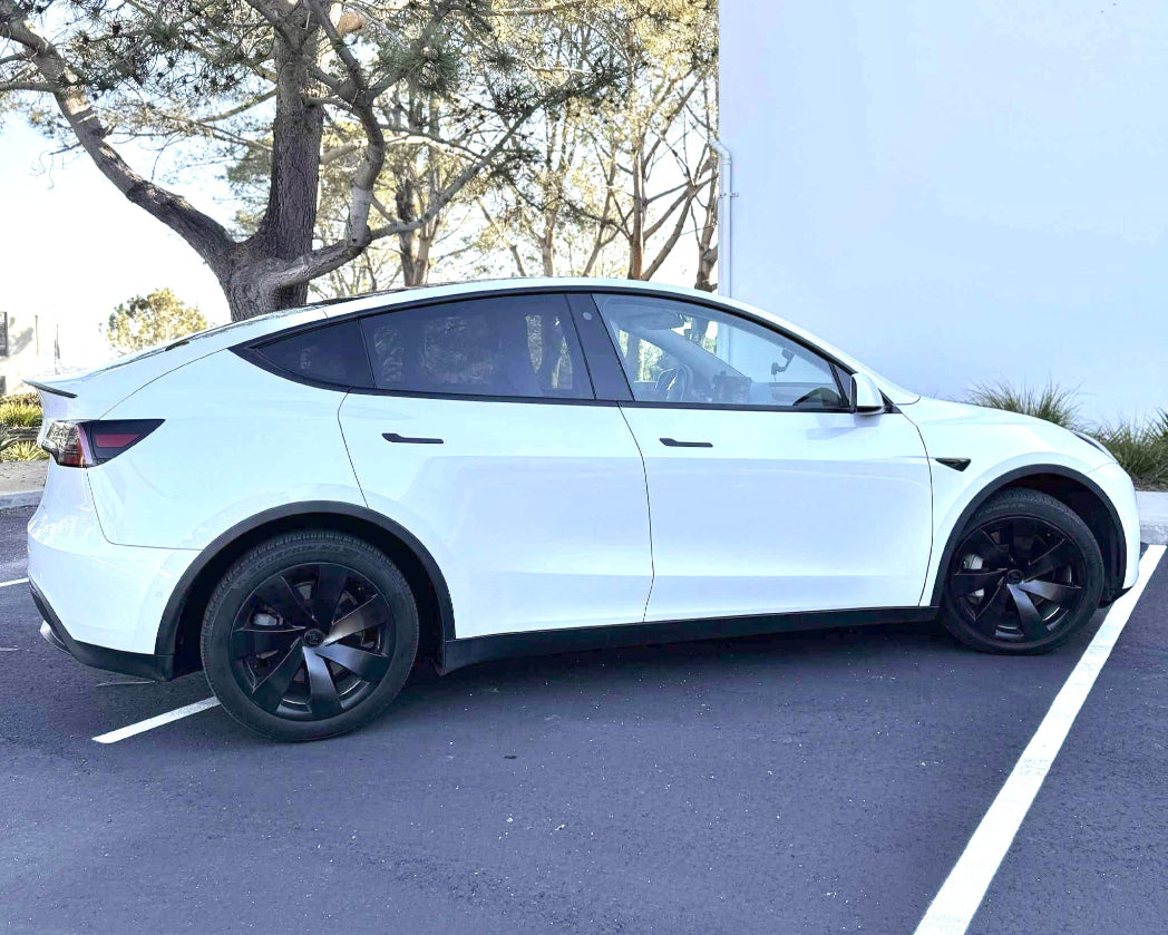 White SUV parked in a parking lot with trees in the background