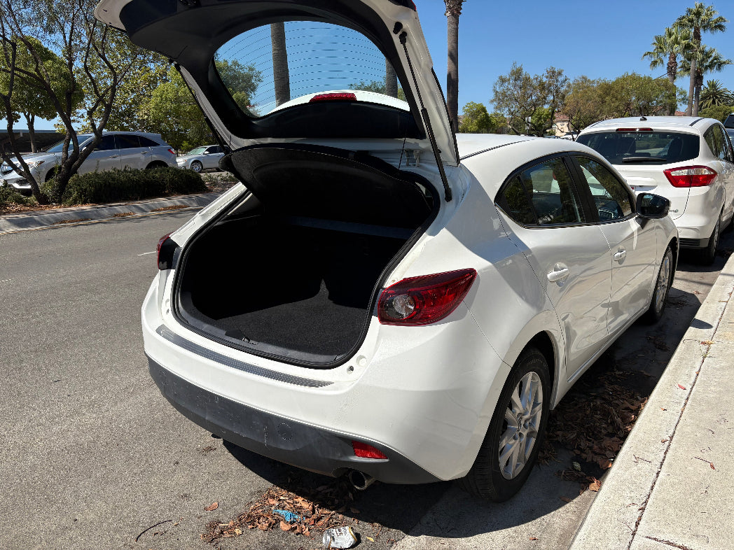 White car with open trunk in a parking lot