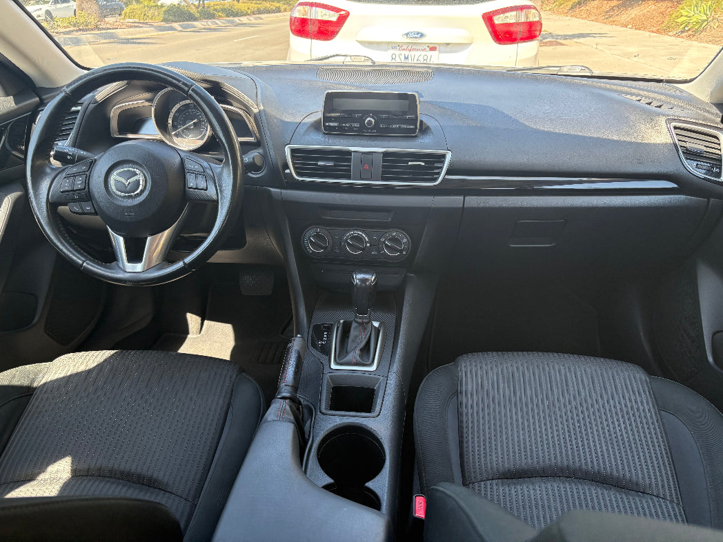 Rental Car interior with steering wheel and dashboard in a sunlit setting
