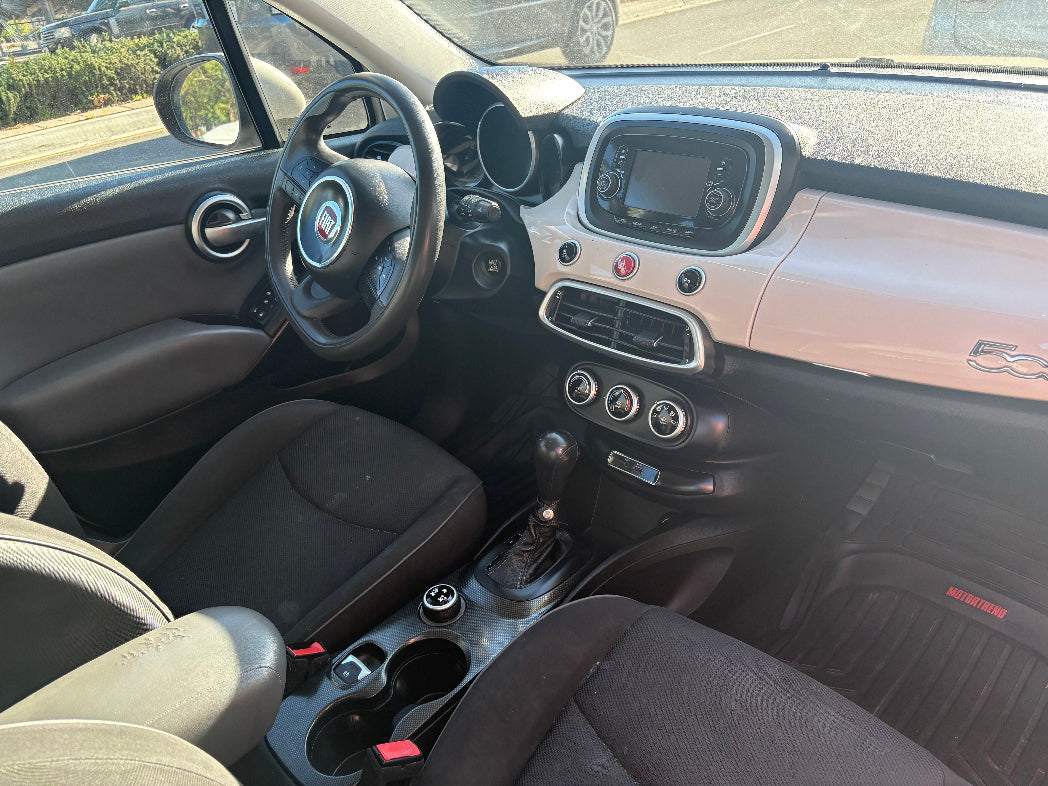 Car interior with steering wheel, dashboard, and seats.