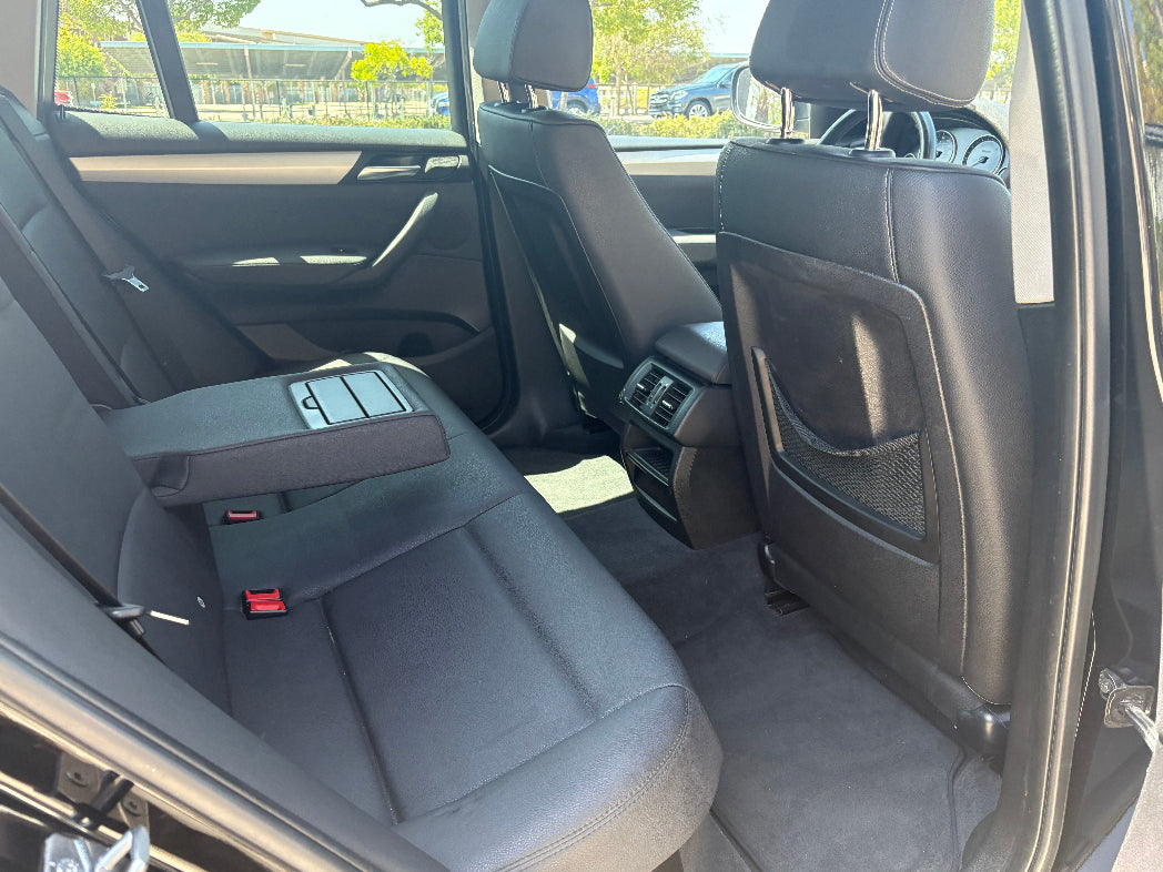 Back seat of a car rental with visible controls and armrest.