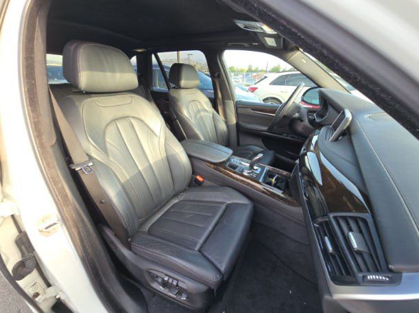 Car interior with gray seats and dashboard in a parking lot.