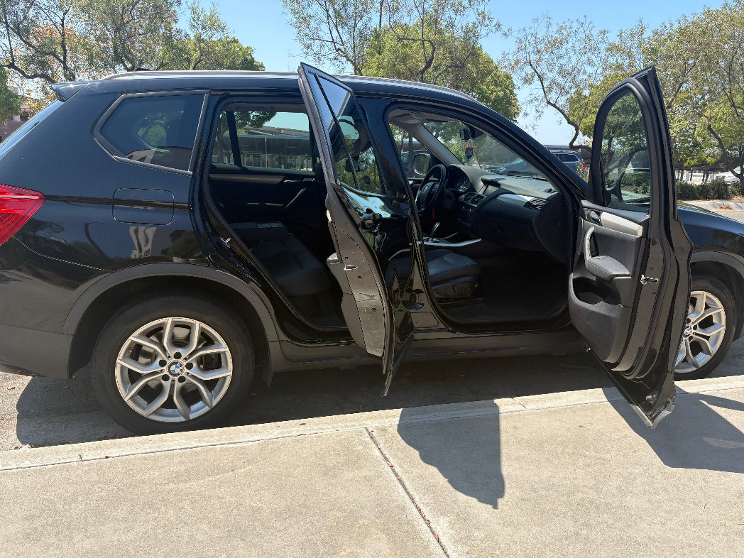 Black SUV rental with doors open in a parking lot