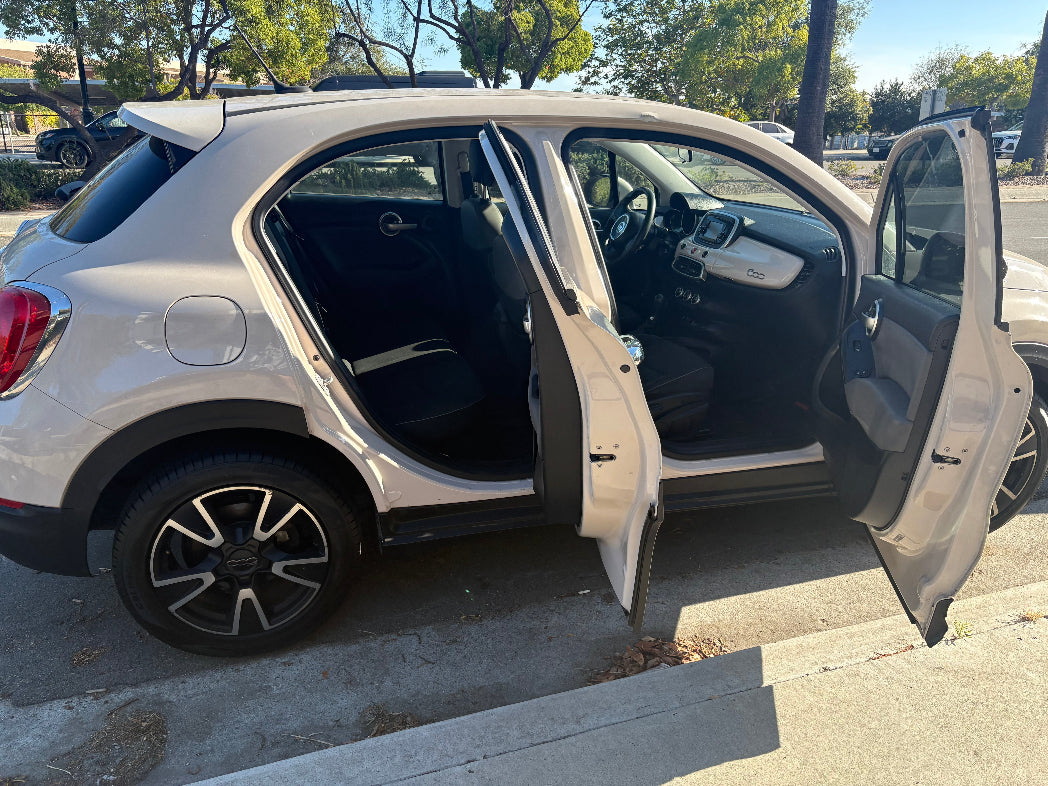 White SUV with doors open on a street