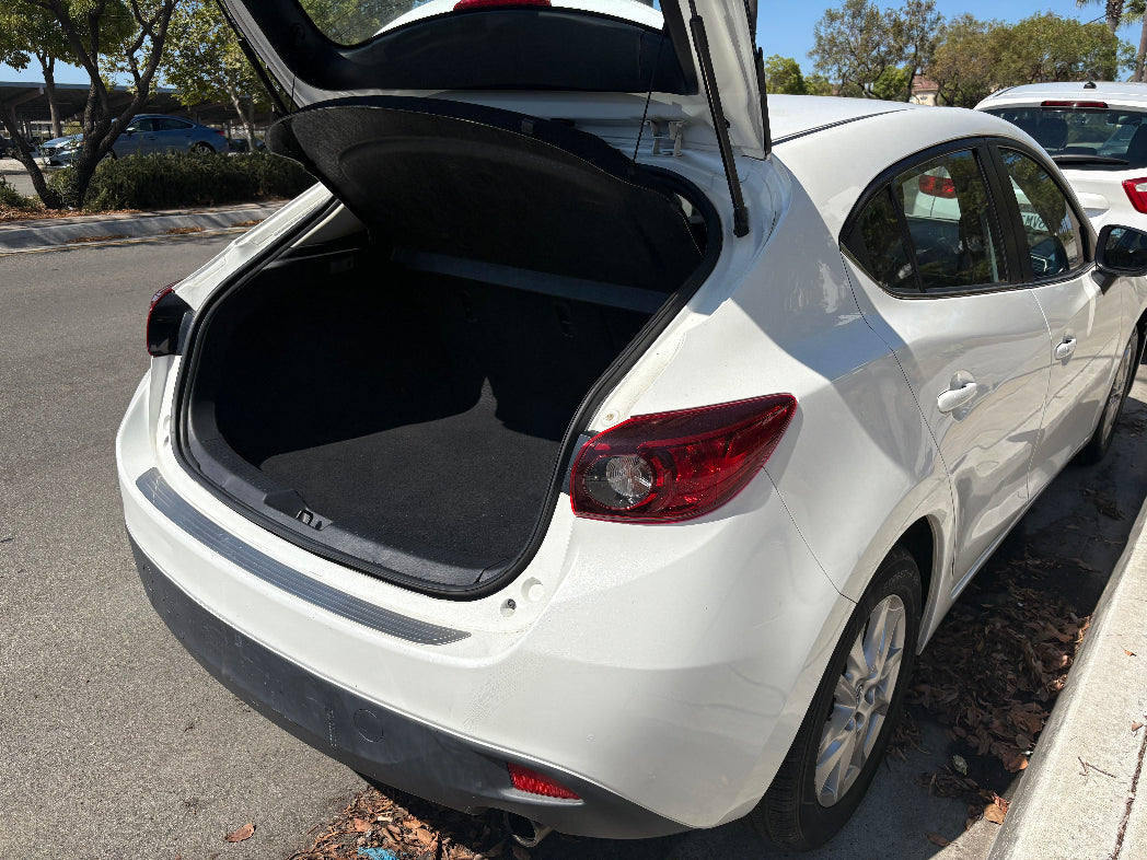 White car with open trunk in a parking lot