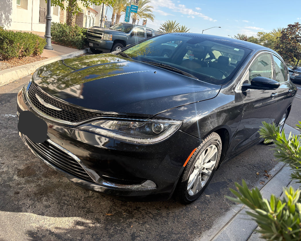 Black car parked on a street with a clear sky