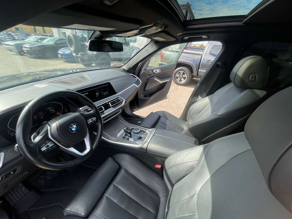 Car interior with steering wheel and dashboard, showing a BMW logo.