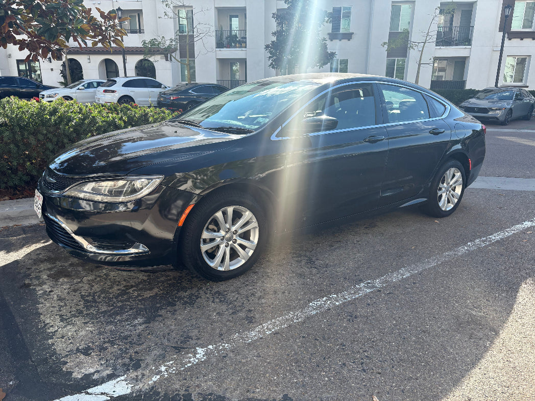 Black sedan car parked on a street with buildings in the background