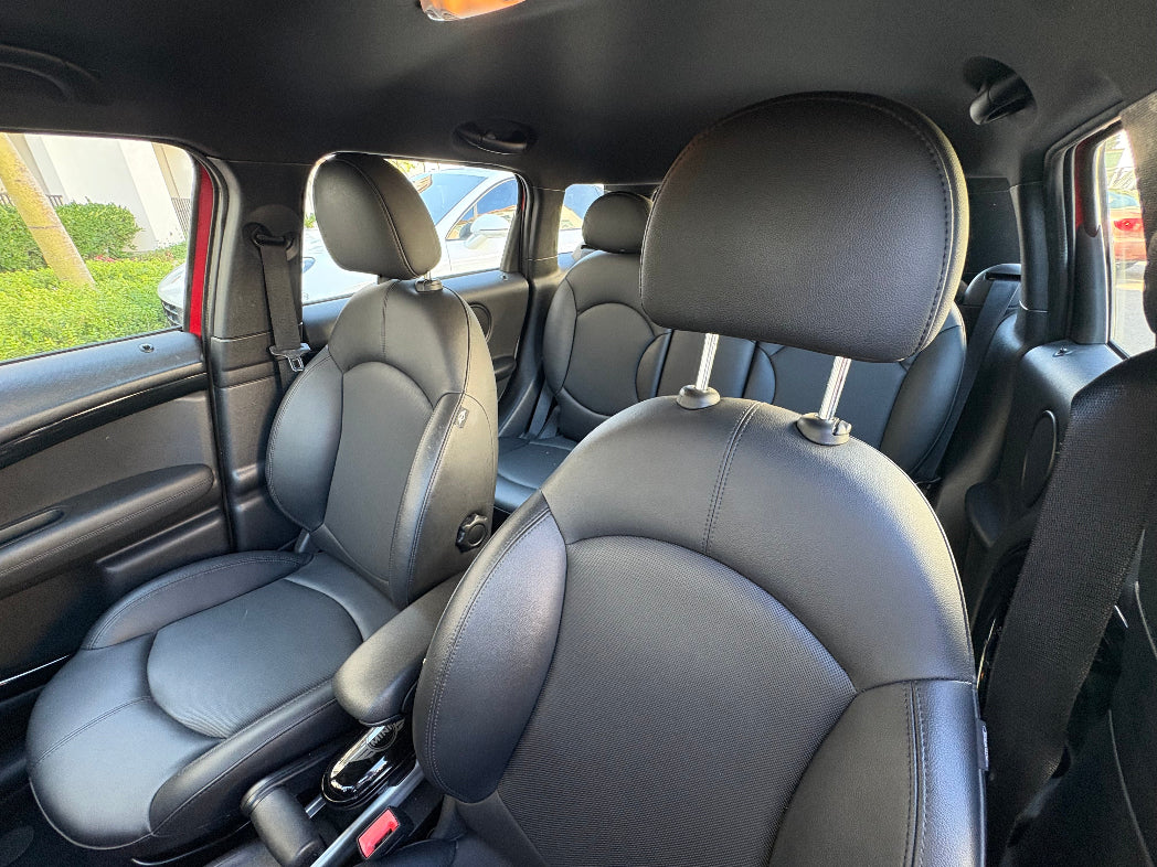 Gray leather interior of a car with visible windows and door panels.