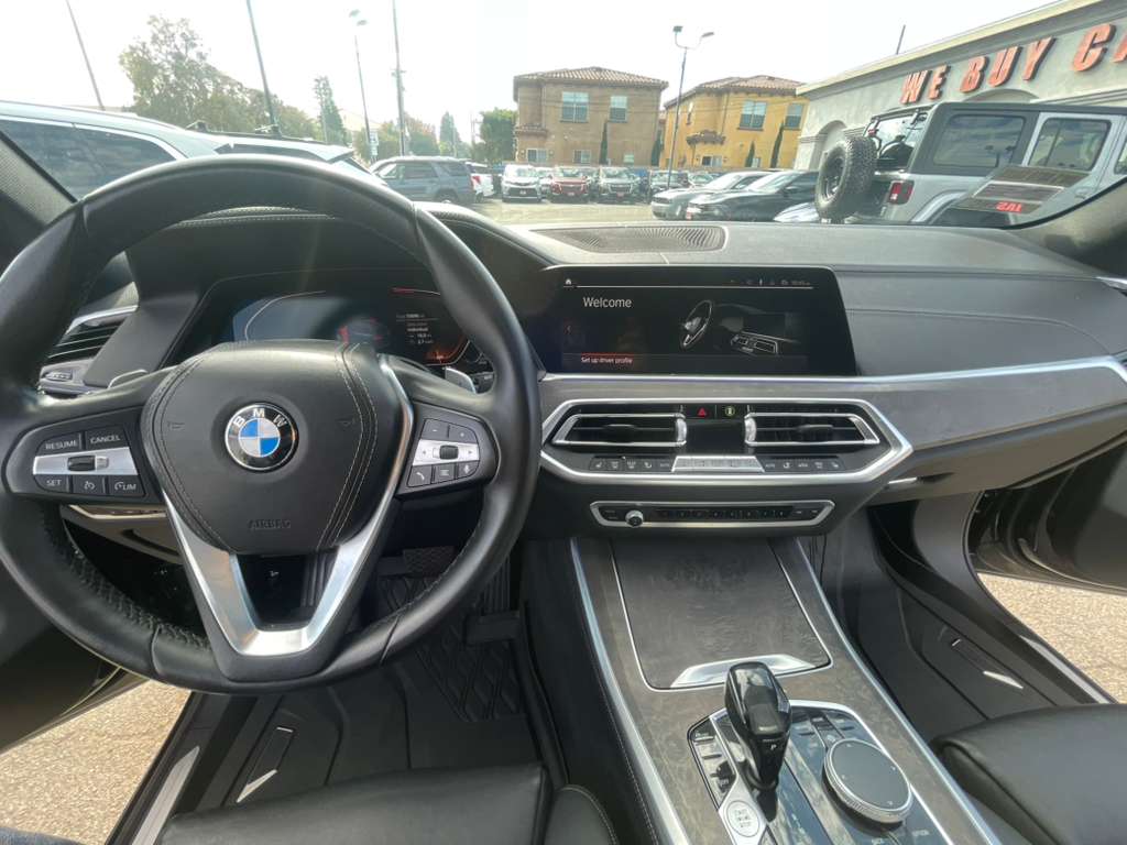 Car interior with steering wheel and dashboard, showing a BMW logo.