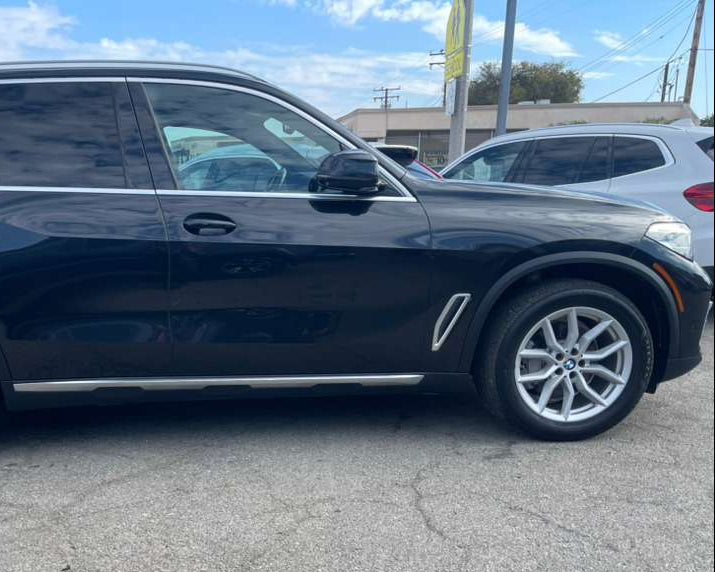 Black SUV parked on a paved surface with a clear sky in the background