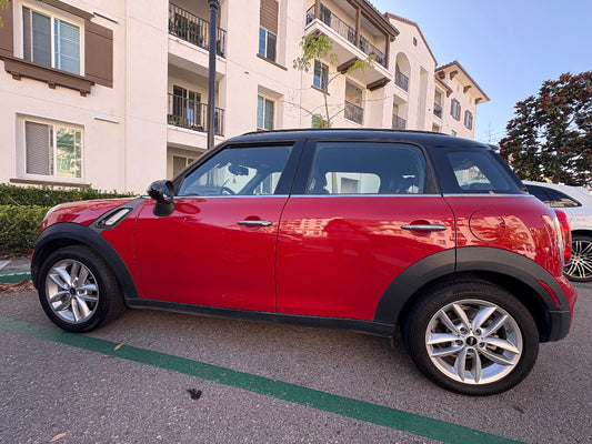 Red Mini Cooper parked in front of an apartment building