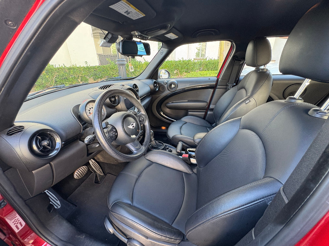 Car interior with gray seats and dashboard, showing steering wheel and door panels.
